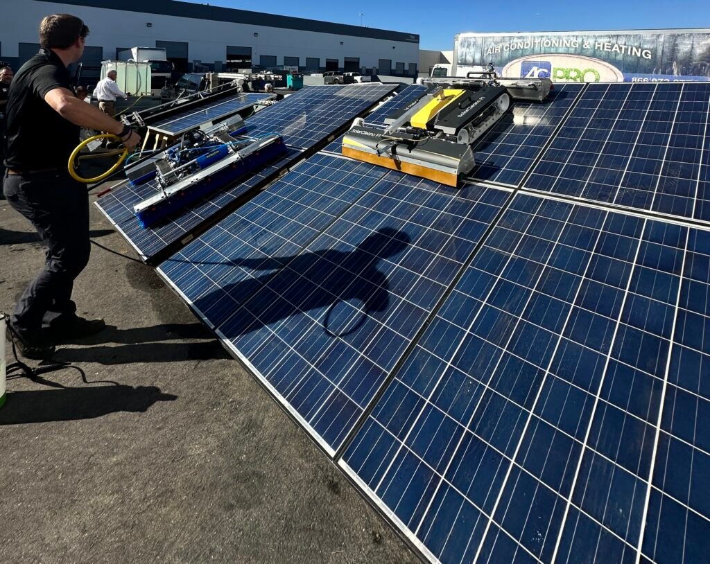 Two solar panel cleaning robots on a solar array